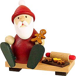 Weihnachtsmann auf Bank mit Lebkuchenmann, Backblech und Nudelholz - 9 cm