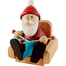 Weihnachtsmann strickend im Sessel - 9 cm